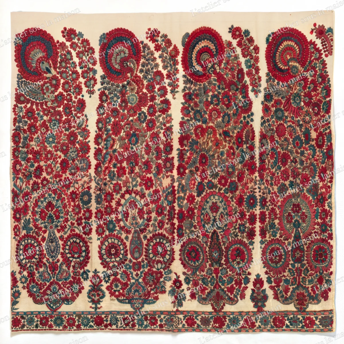 Rangée de grandes palmes cachemire fleuries, rouges, vertes et bleues, sur fond crème.